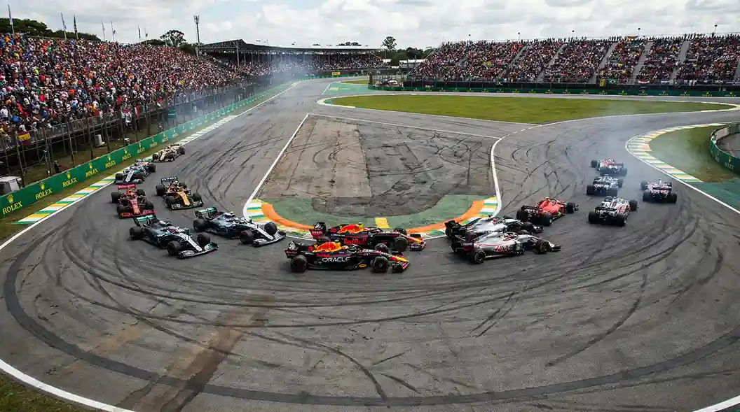 Current image: Plusieurs monoplaces de F1 dans le premier virage après le départ de la course